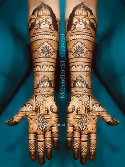 A beautiful example of symmetrical bridal mehendi. The design is balanced with lotus motifs on the forearms and elegant paisley teardrops on the palms.