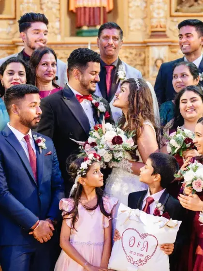 A beautiful group photo of the couple with their family and bridal party after the ceremony.