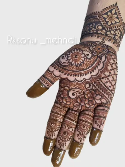 An intricate and full-coverage design perfect for a festive occasion. The pattern combines floral mandalas with detailed work on the fingers and a geometric wristband.
