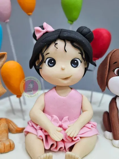 A detailed shot of the custom figurine for a 2nd birthday cake, capturing the sweet innocence of the little girl.