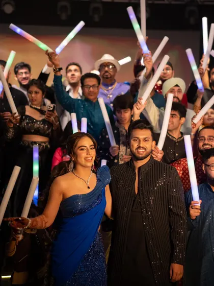 The grand finale of the Sangeet, with the couple and all their friends on stage with LED foam sticks.