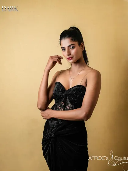 A portrait of a model wearing the black corset gown, highlighting the delicate straps and the elegant neckline.