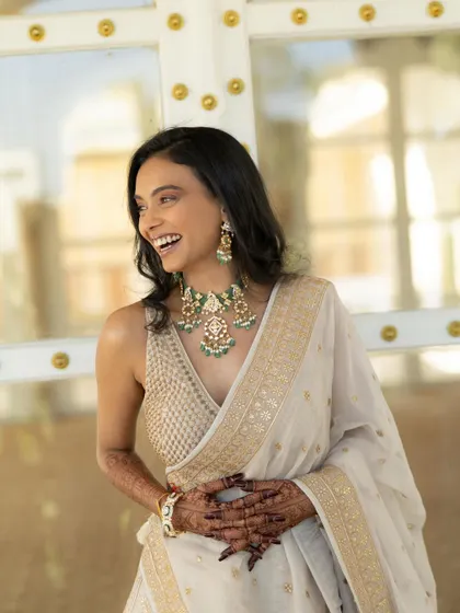 A candid shot of the bride laughing heartily, showcasing her beautiful jewelry and the joy of the moment.
