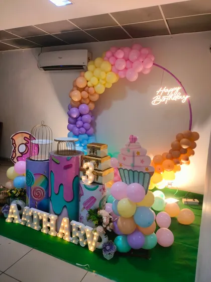 Another view of the candy-themed party, showing the full setup with marquee letters and a 'Happy Birthday' neon sign.