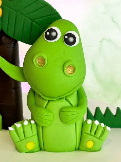 Check out the detail on this cute little fondant dinosaur. We handcraft these figures to bring personality and fun to our dinosaur-themed cakes for kids.