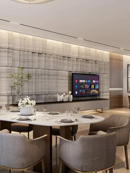 The living and dining areas of this Nagpur apartment are designed as a sanctuary from the bustling world outside. A fluted marble feature wall behind the television creates a textured focal point, complemented by neutral furnishings and warm wood accents for a serene atmosphere.