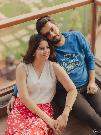 A relaxed and casual portrait of the couple on a balcony, capturing a moment of quiet togetherness.