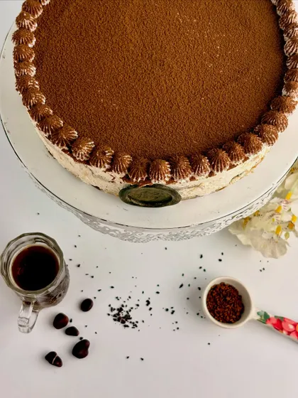 A top-down view of the Tiramisu, highlighting the rich cocoa dusting and the delicate piping around the edge. It’s simple, elegant, and incredibly delicious.
