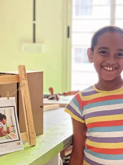 A huge, happy smile from a student who successfully built her own wooden photo frame.