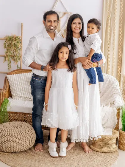A beautiful, relaxed family portrait in our boho studio. The family's coordinated white outfits and bare feet give the photo a natural and down-to-earth feel.