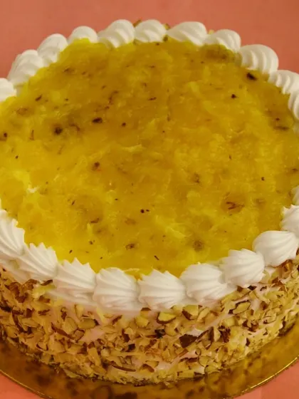 Our premium Pineapple Cake, a classic favorite. It's topped with a sweet pineapple compote and decorated with chopped nuts around the side.