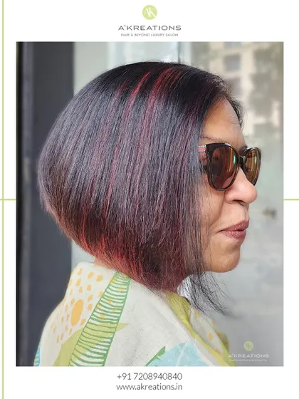 A fiery touch of red highlights on a chic, angled bob. This look is perfect for adding a pop of color and personality.