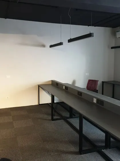 Another view of the Amigo co-working office project. The custom-built long desks feature integrated power outlets for a clean, wire-free setup.