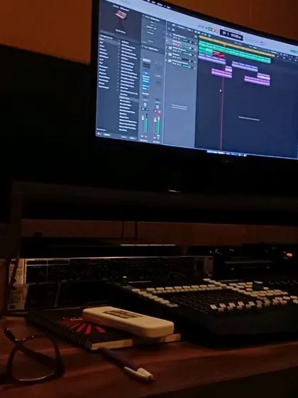 A close-up of my workstation during a writing session. You can see the audio tracks on the screen, my notebook for lyrics, and my glasses for the long hours.