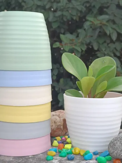 These are my round, ribbed plastic pots, available in a variety of pastel and neutral colors. They are lightweight, durable, and perfect for small to medium-sized artificial plants.