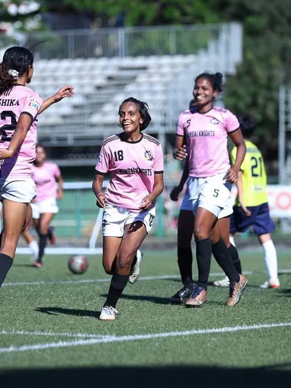 Players celebrating a goal, a moment of shared success on the field.