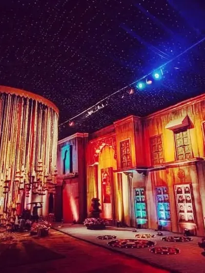 A shot from one of my large-scale productions, showcasing a recreated street scene with dramatic lighting and a massive hanging installation of bells and candles.