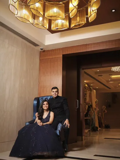 A stylish portrait of the engaged couple, using the venue's modern chandelier and interior design to create a sophisticated and memorable photograph.