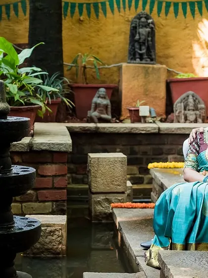 A serene portrait of a couple in a traditional courtyard with a water feature. We find beauty in quiet, peaceful settings.