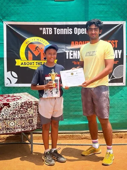 A winner receives his trophy from a senior player, a tradition we encourage at our academy.