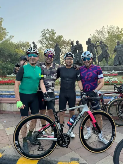 Four of our dedicated members posing with a sleek Cannondale road bike.