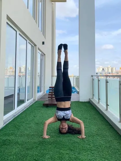 Taking the practice outside. An inversion on a balcony is a reminder that you can find a new perspective anywhere. Upside down is the new normal.