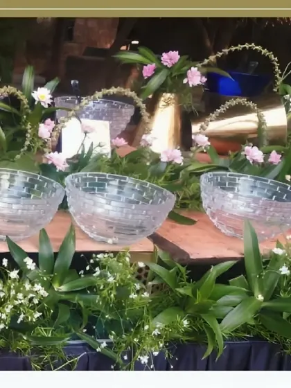 Our attention to detail is evident in this shot of crystal-clear serving bowls set amidst fresh flowers and greenery, creating a refreshing and elegant look for a salad or dessert bar.