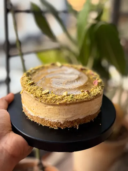 A side view of my Kunafa Cheesecake, showing the distinct layers of crunchy pastry and smooth, creamy filling.