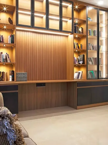 This wall-to-wall bookshelf is designed to be a sanctuary. The warm wood, soft lighting, and cozy seating create a space to slow down, unwind, and get lost in a story.