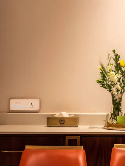 A smart panel on a clean, white countertop, offering unobtrusive control over the room's functions.