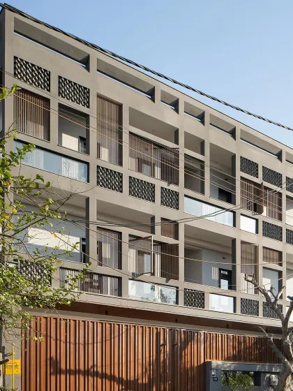 This is the Urban Oasis, a home designed as a modern bastion in Hapur. Its facade is a hard shell with a soft core, using a grid of raw concrete and fly ash bricks to shield the interiors from a harsh industrial environment while allowing light and air to flow freely, creating a breathable, tranquil sanctuary within.