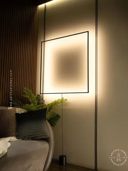 This unique floor-to-ceiling fixture features a large, suspended square frame that washes the wall with a soft, ambient light. It acts as both a light source and a bold, graphic art piece for a contemporary living room.