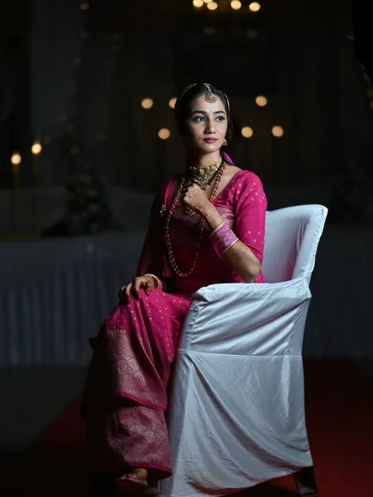 A dramatic, low-light portrait of the bride during her Oorkuduva ceremony. Her makeup looks stunning even in the moody lighting.