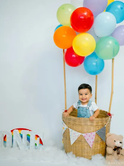 A full view of the hot air balloon setup, complete with a teddy bear co-pilot. It’s a whimsical theme that results in magical photos.
