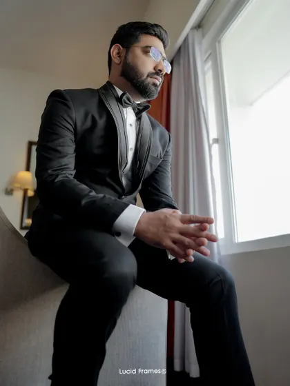A stylish, pensive portrait of the groom sitting by the window.