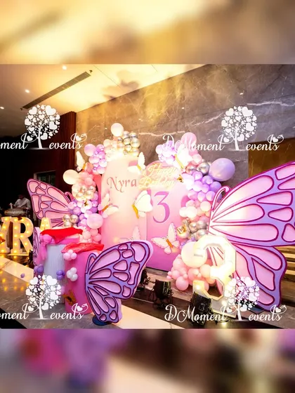 A side view of the butterfly stage, emphasizing the large, intricately designed butterfly wing props that frame the central display.