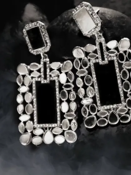 To give fashion accessories a high-end, editorial feel, I play with dramatic lighting and textures. These intricate earrings are set against dark, smoky stones, making the craftsmanship and reflective surfaces stand out.