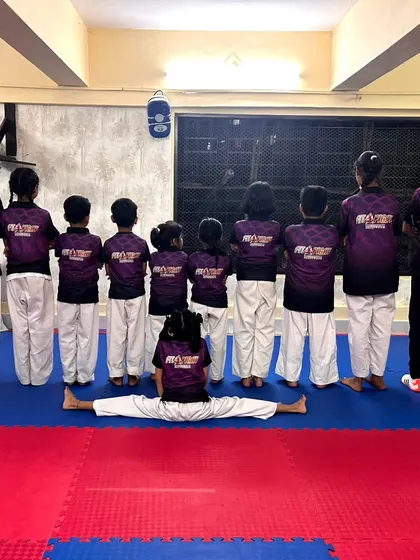 We are a team, front and back. Our students show their unity and flexibility, with one member holding a perfect center split.