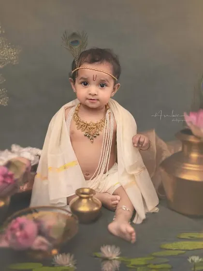 A direct and engaging portrait of a baby Krishna, looking straight into the lens. The traditional jewelry and tilak complete this adorable and authentic mythological look.