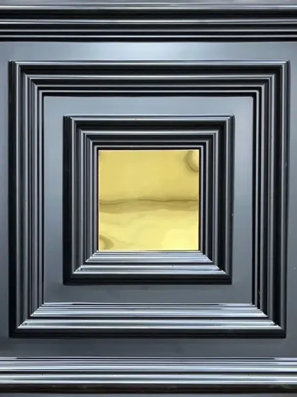 A black PVC panel with a gold mirror accent. The combination of the dark, grooved frame and the bright metallic center creates a bold and luxurious look.