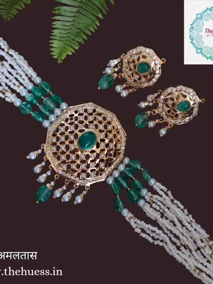 The 'अमलतास' (Amaltas) necklace set, a stunning Hyderabadi choker with a large central motif and emerald green beads. This piece is the epitome of royal elegance.