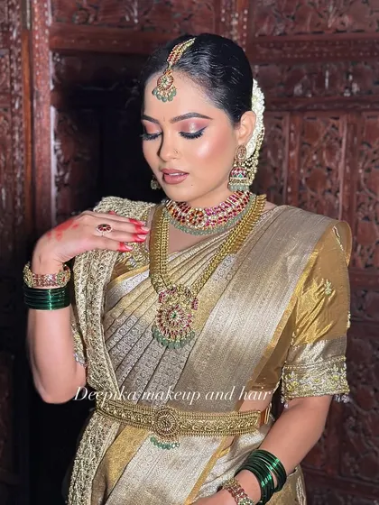 This image captures the complete elegance of a South Indian bride, from the maang tikka to the waist belt, all tied together with flawless makeup.