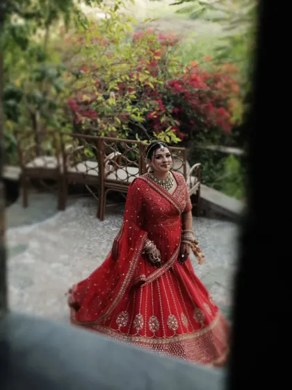 A beautiful portrait of the bride framed through a window, looking out with a gentle smile.