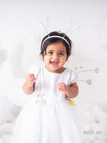 A happy smile amidst the clouds. The all white, dreamy setup is perfect for creating angelic and timeless first birthday portraits.