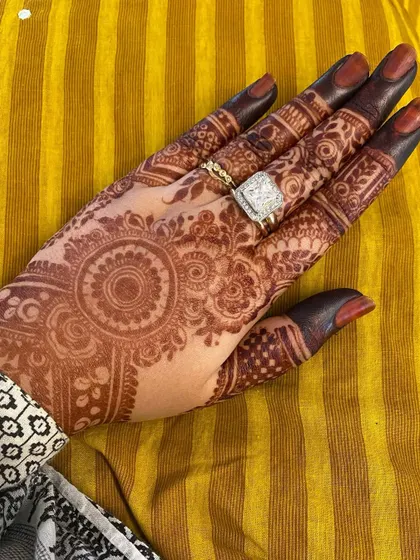 A beautiful stain on the back of the hand, adorned with rings. The henna complements the jewelry perfectly.