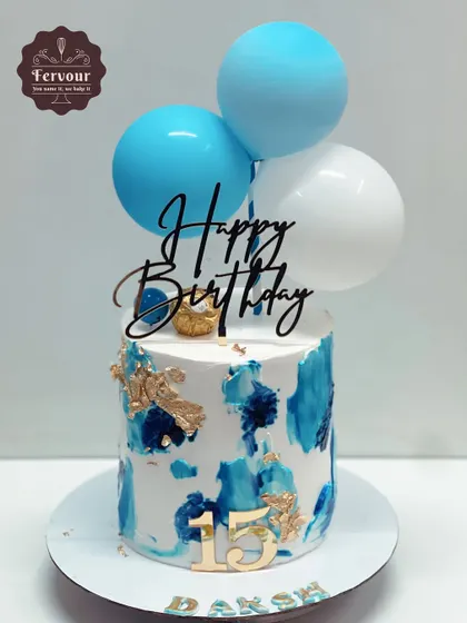 A blue and white abstract cake decorated with balloons. This simple design is vibrant and celebratory, perfect for a 15th birthday.