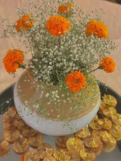 A simple yet elegant centerpiece for a traditional function. A vase of marigolds and baby's breath adds a touch of freshness and color to the guest seating areas.