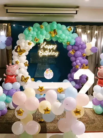 A full view of the Peppa Pig themed second birthday, showing the balloon arch, character foils, and room layout.