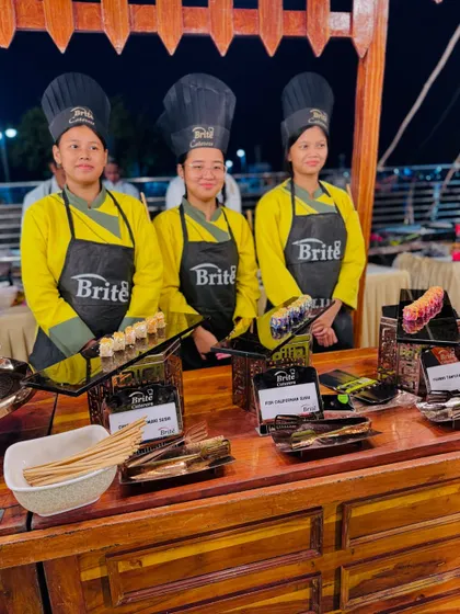 My professional sushi team ready to serve, showcasing their coordinated uniforms and neat presentation.