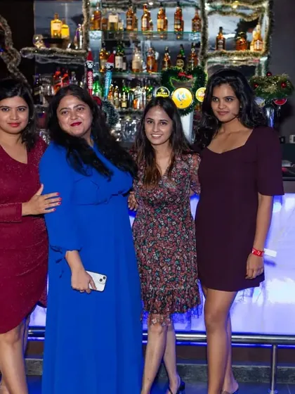 A group of ladies looking glamorous for a night out, posing in front of the bar.